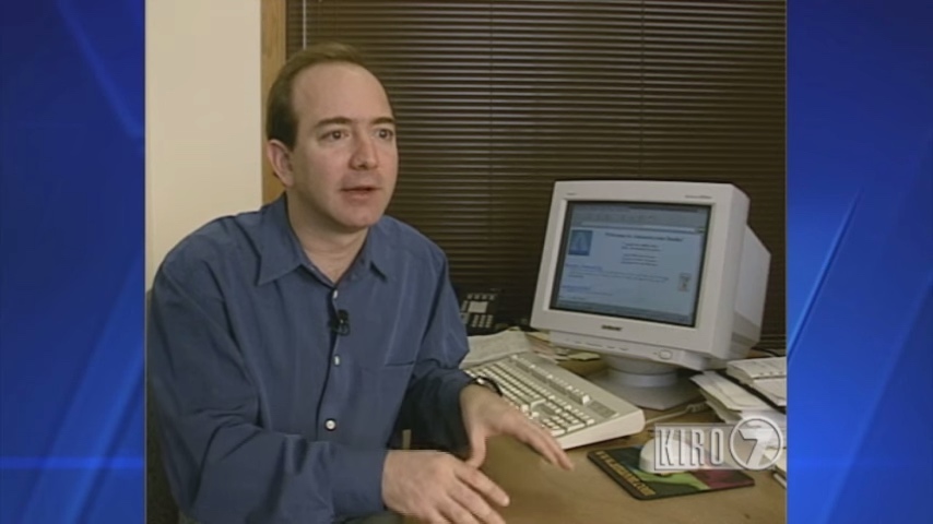 Jeff Bezos sitting at desk in front of a computer with Amazon.com in 1997
